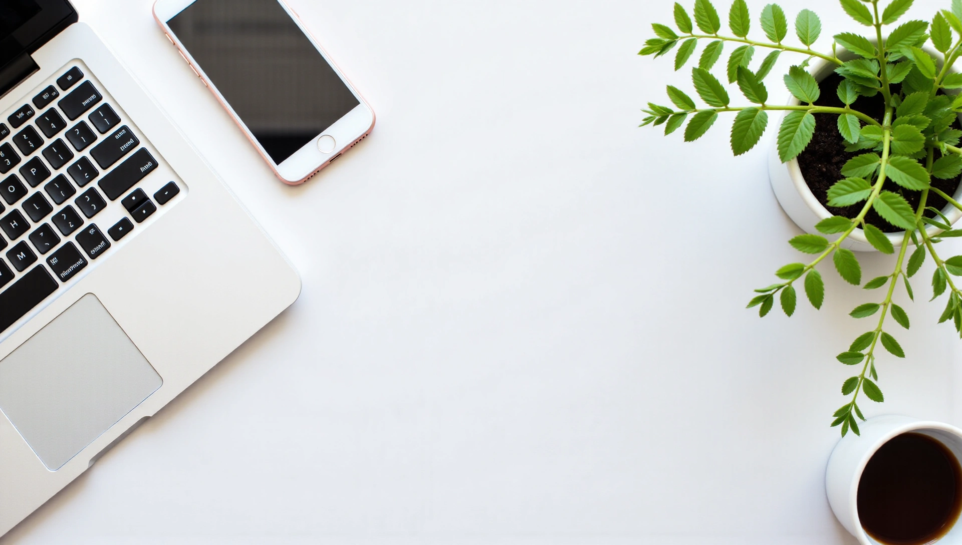 Scrivania moderna con laptop, telefono e pianta che simboleggia comunicazione e benessere